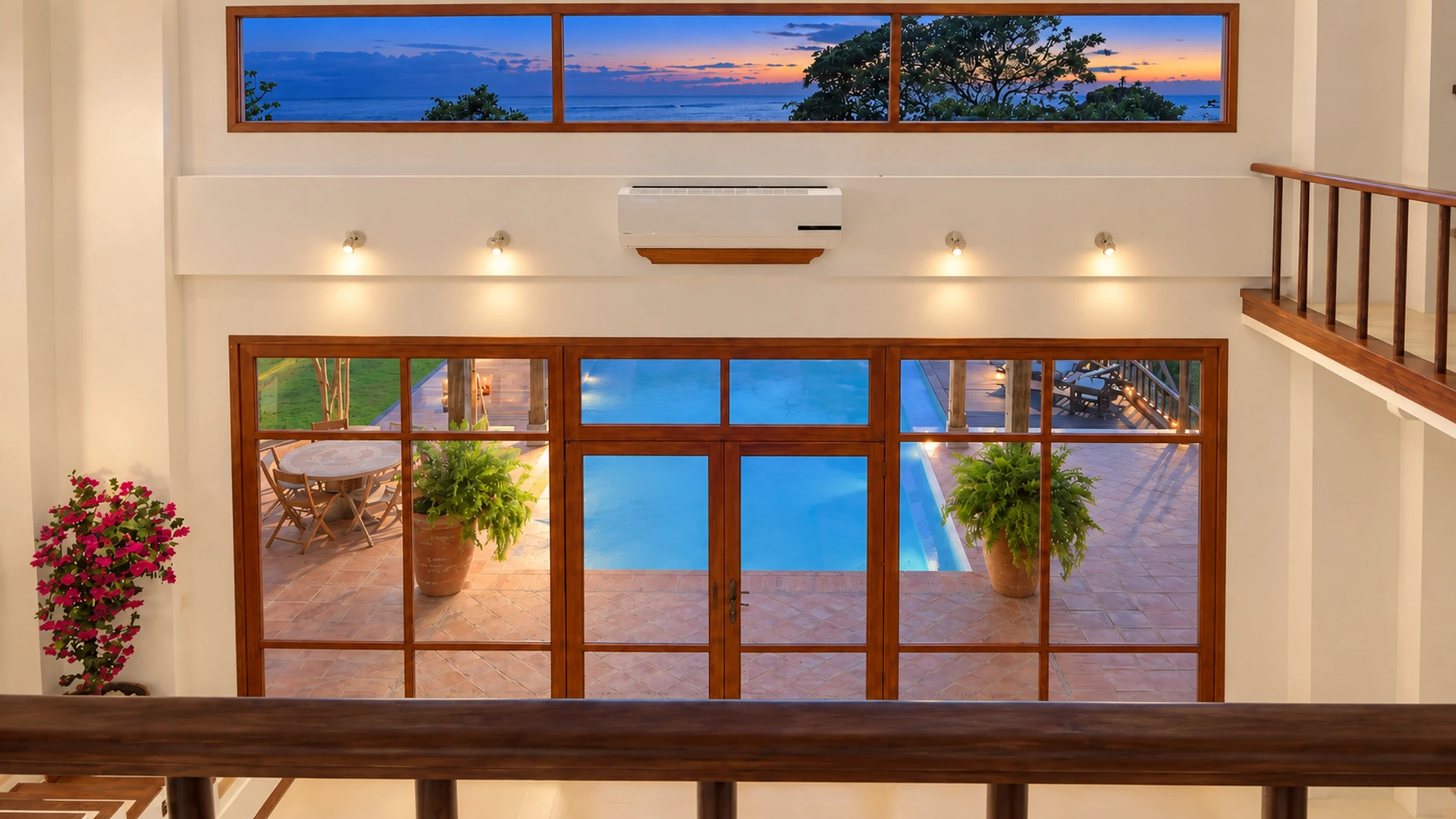 The double-height living room at Villa Alborán, opening onto the pool at sunset