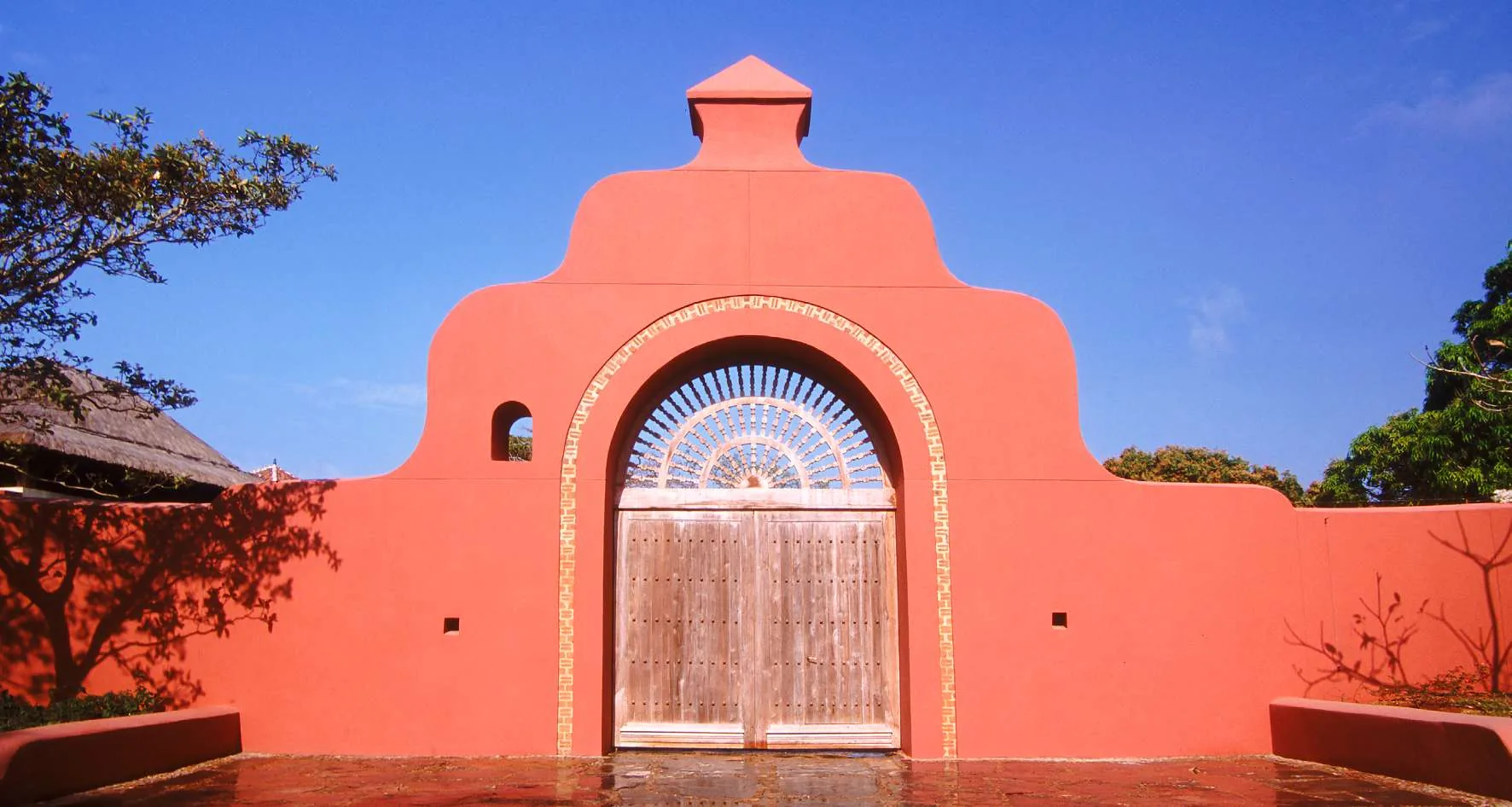 The entrance gate at Villa Camilla, an arch and a wooden door in a terracotta wall