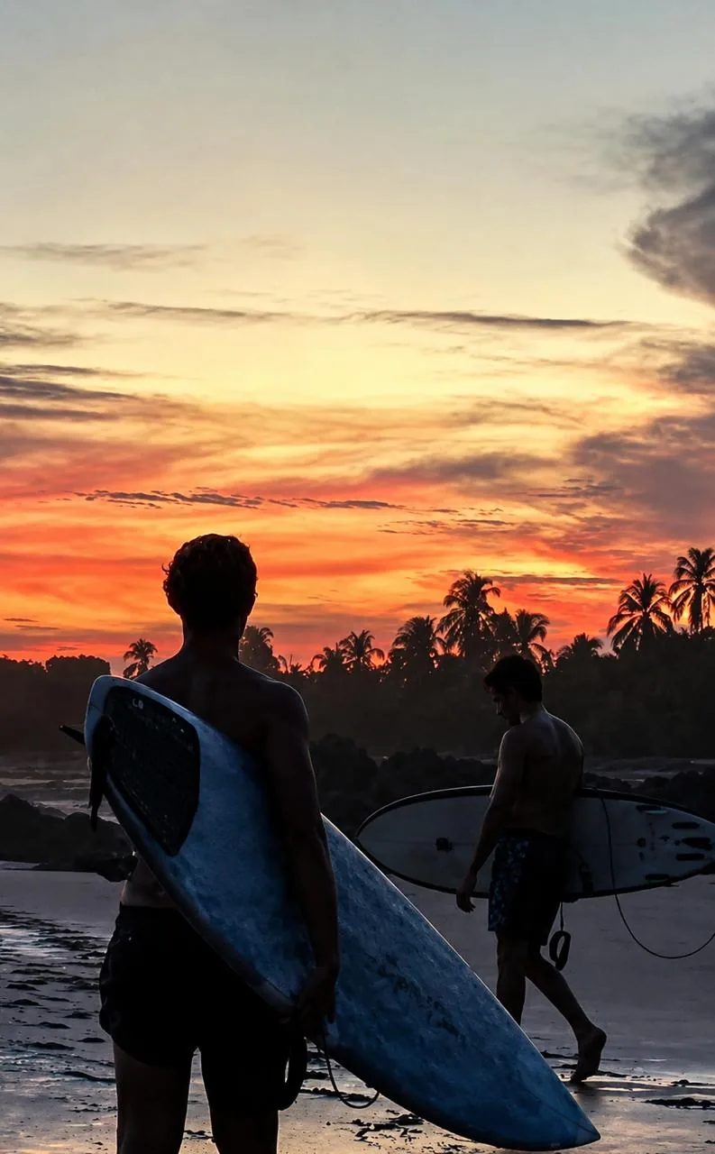 Surfers leaving the water at dusk at Playa Destiladeros